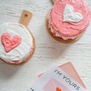 Heart-shaped cakes and a love note on white background, perfect for romantic occasions.